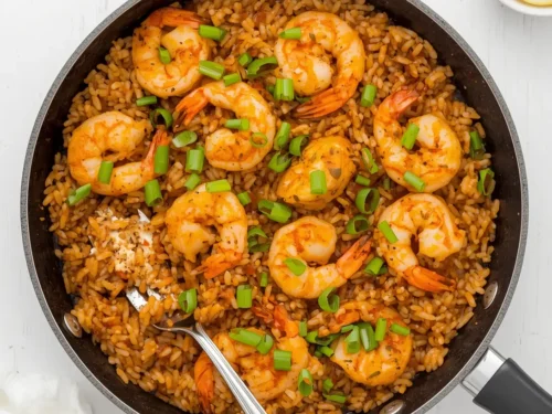 A vibrant Cajun shrimp and rice skillet with spices and vegetables.
