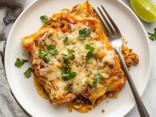 A serving of Crockpot Chicken Quinoa Enchiladas topped with fresh cilantro in a bowl.