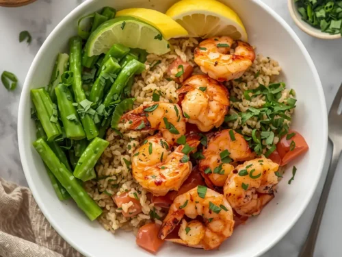 A vibrant grilled shrimp and brown rice buddha bowl filled with fresh vegetables