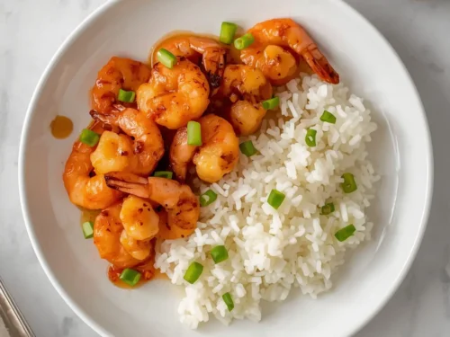 A vibrant dish of honey chili grilled shrimp served with fluffy white rice.