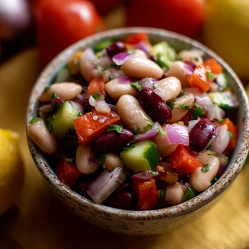 A vibrant Italian grinder bean salad with mixed beans and fresh vegetables.