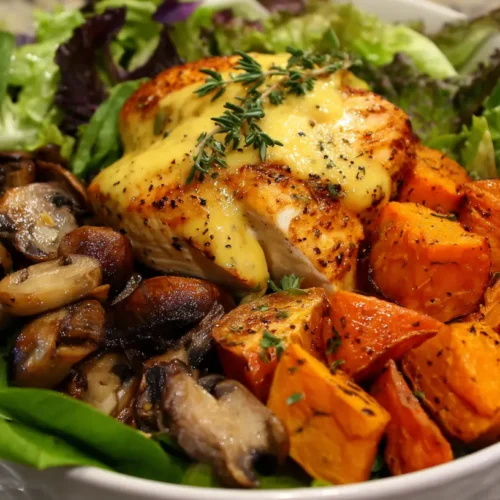 A vibrant Maple Dijon Chicken Bowl, artfully arranged with tender chicken, roasted sweet potatoes, and colorful vegetables.