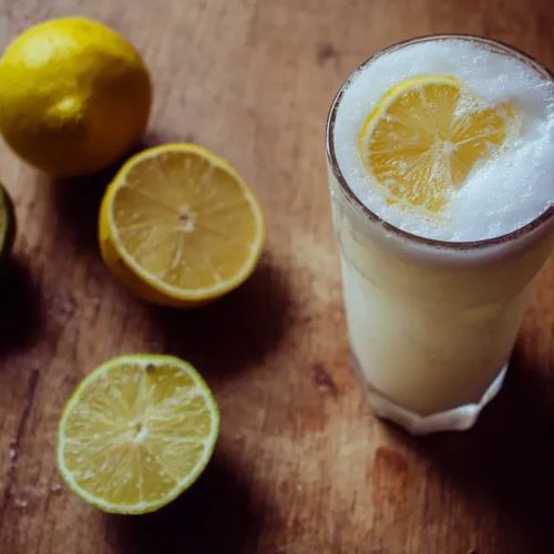 A glass of refreshing Brazilian lemonade drink with lime slices and ice
