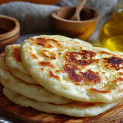 A freshly baked Turkish Bazlama bread, soft and round, on a wooden surface.