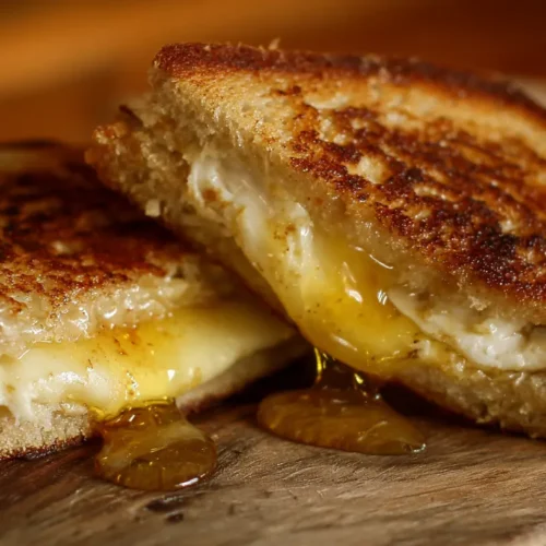A golden-brown goat grilled cheese sandwich drizzled with honey