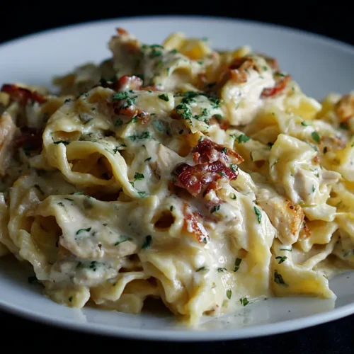 A plate of creamy Marry Me Chicken Pasta garnished with fresh herbs and a sprinkle of parmesan.