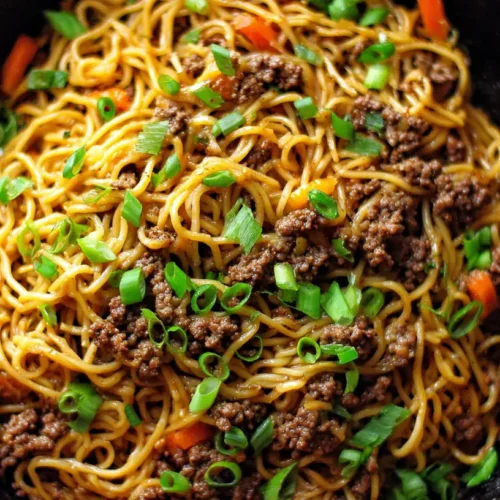 A close-up of Mongolian ground beef noodles in a bowl, ready to eat.