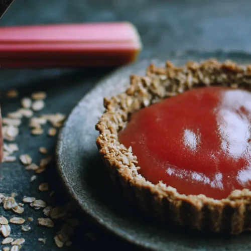 A freshly baked rhubarb tart with a golden crust and vibrant red rhubarb filling.