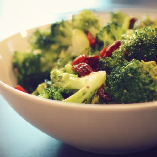 A vibrant bowl of fresh broccoli salad with various ingredients