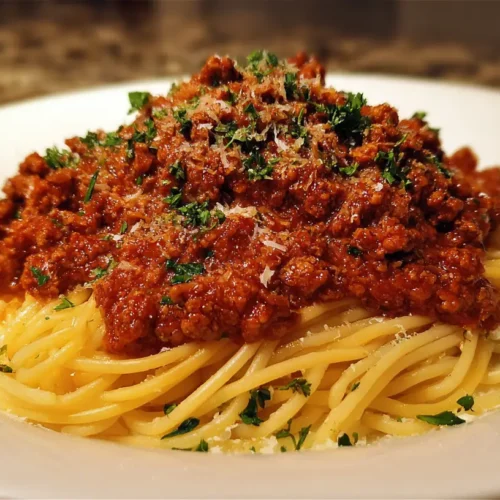 A steaming bowl of classic spaghetti bolognese with rich meat sauce.
