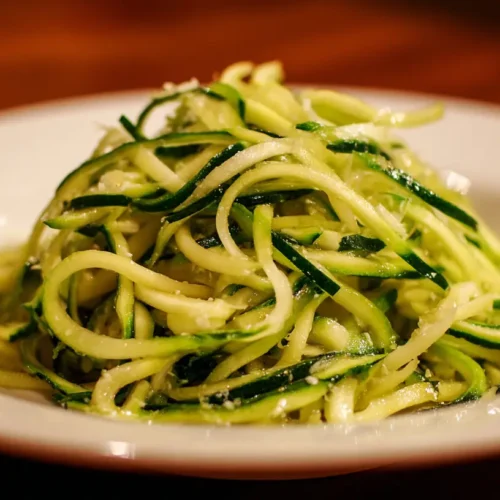 A vibrant bowl of fresh green Zucchini Noodles ready to be served.